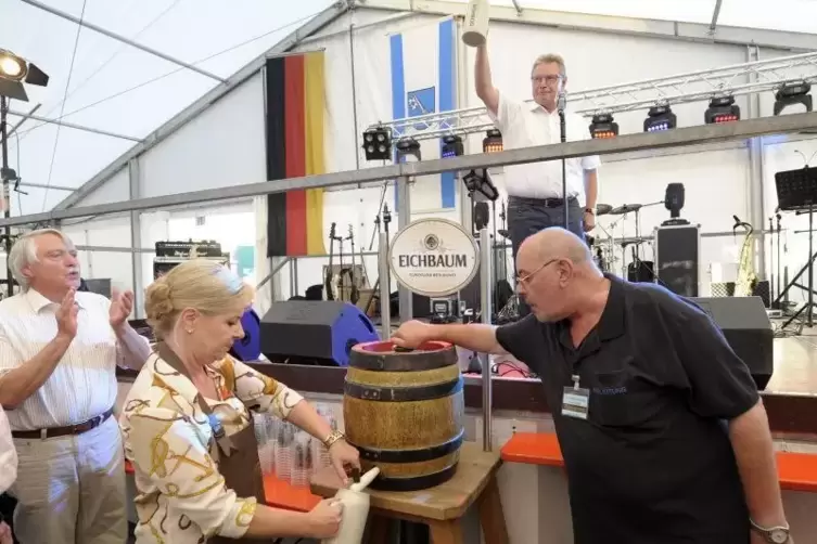Hans-Dieter Schneider prostet den G&auml;sten zu, w&auml;hrend Andrea Franz zapft.  Foto: KUNZ