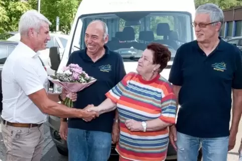 Bürgermeister Andreas Müller überreicht Käthi Schreiner einen Blumenstrauß. Sie war der 1000. Fahrgast des Bürgerbusses. Rechts 