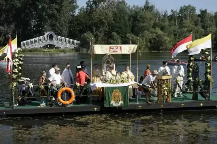 Der schwimmende Altar ist mit Fahnen und Blumen geschm&uuml;ckt.  Foto: BOLTE