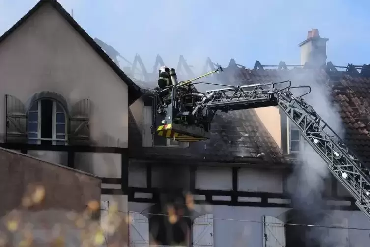 Feuerwehrleute löschten den Brand in dem zweistöckigen Gebäude im französischen Schiltigheim.  Foto: Frederick Florin/dpa 