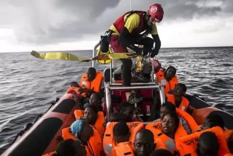 Gerettet: Ein Helfer öffnet eine Rettungsdecke für Flüchtlinge, die von einem privaten Rettungsschiff entdeckt worden waren.