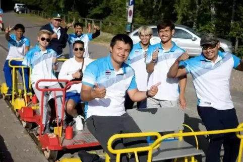 Fühlen sich sichtlich wohl: die thailändischen Leichtathleten auf der Draisine.