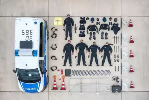 Rund um die Welt posieren Feuerwehrleute und Polizeibeamte wie Actionpuppen neben ihren Fahrzeugen und sauber aufgereihtem Zubeh