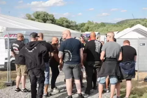 Besucher stehen vor dem Veranstaltungsgelände bei einem Rechtsrock-Festival.