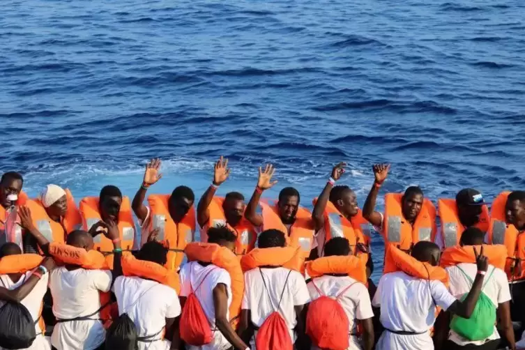 Die von der &bdquo;Ocean Viking&ldquo; geretteten Menschen auf einem Festrumpfschlauchboot, als sie am 24. August zu einem Patrouillenboot d