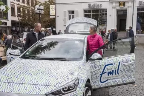 Bürgermeisterin Beate Kimmel steigt in ein E-Fahrzeug der Stadtwerke ein; links SWK-Vorstandsmitglied Richard Mastenbroek.