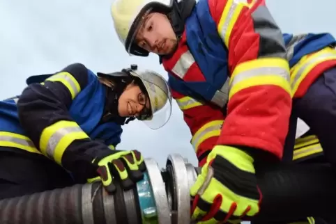 Angelique Rost von der Feuerwehr Iggelbach und Marc Eichhorn (FW Deidesheim) lernen gerade, eine Saugleitung zu legen.
