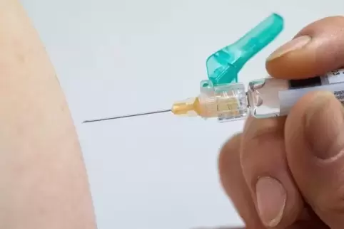 Ein Arzt impft eine Person gegen Grippe.