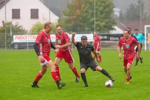 Promi-Kick im Dauerregen: Fabrizio Hayer (schwarzes Trikot) im Duell mit Handball-Star Christian Schwarzer (links).