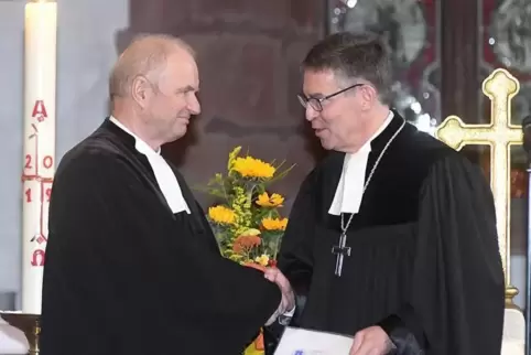 Dekan Stefan Dominke (rechts) händigt Pfarrer Gerhard Ehrlich die Entlassungsurkunde aus dem aktiven Dienst aus.