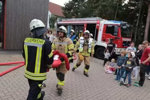 Die Wehrleute bergen eine vermisste Person. Etliche Zaungäste beobachten die Übung in der Sausenheimer Kita.