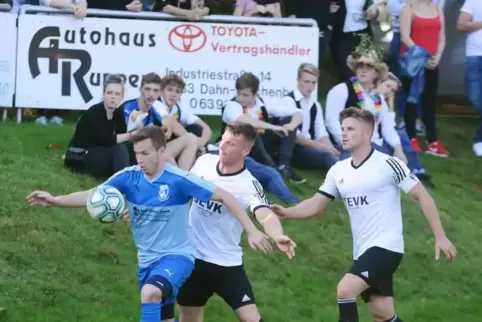 Würdige Kulisse: Auch die Straußjugend verfolgte, wie Hinterweidenthals Daniel Tretter (blau) den Ball gegen Justin Danny Müller