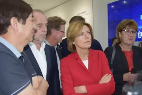 CATL-Top-Manager Zening Yu erläutert Malu Dreyer die Abläufe der Batterieproduktion. Rechts: Martina Nighswonger von der IHK der