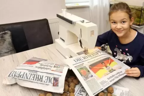 Zeitung statt Plastik: Lilly Neumann näht zwei Ränder der RHEINPFALZ zu und schwupps hat sie eine Tüte, die ein Kilogramm Nüsse 