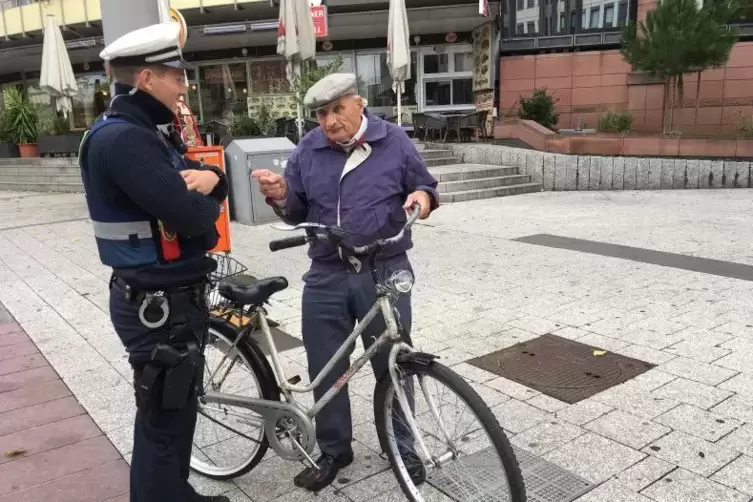 Ein Mann wird von Polizeikommissar Alexander Pilarczjk verwarnt, weil er am Berliner Platz sein Rad schieben muss.
