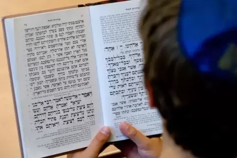 Ein Schüler einer Toraschule schaut in ein jüdisches Gebetsbuch.
