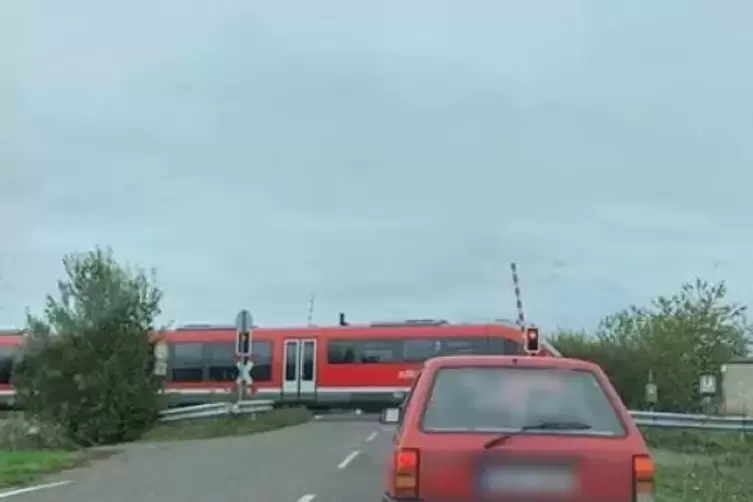 Hinter dem roten Auto zu erkennen: Die Halbschranke diesseits des Zugs ist offen - und die jenseits auch. 