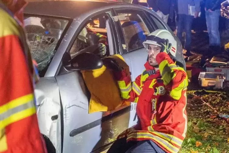 Ein Feuerwehrmann schaut in den Autos nach den Verletzten