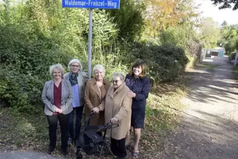 Gruppenbild mit Damen: Ein neues Straßenschild steht an der Kleingartenanlage am Brückelgraben.