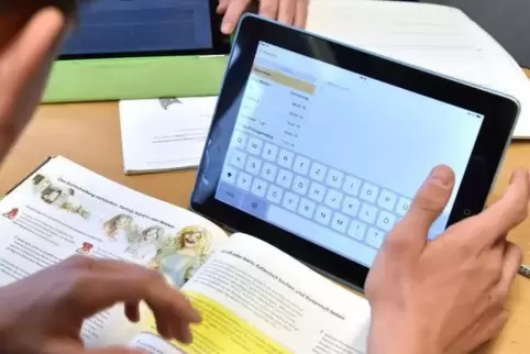 Ein Schüler arbeitet im Klassenzimmer am Tablet.