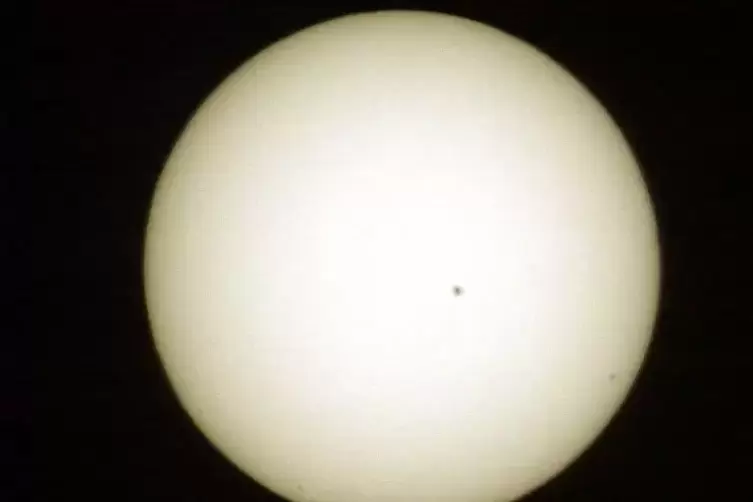 Rechts unten als winziger schwarzer Punkt vor der Sonne ist Merkur zu sehen, in der Mitte ein Sonnenfleck (aufgenommen mit einer