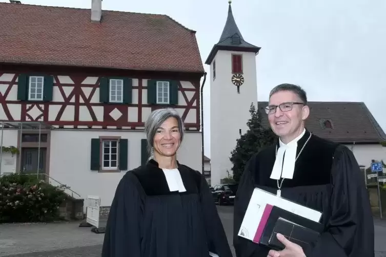 Marie-Luise Lautenbach mit Dekan Stefan Dominke vor Pfarrhaus und Kirche in Bischheim.