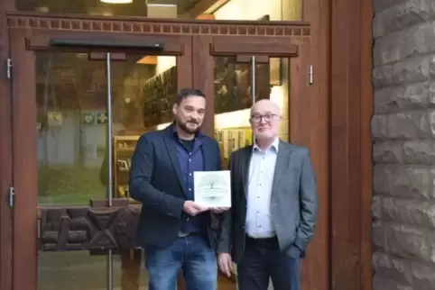 Stiftungsvorsteher Erich Schlick (rechts) und der neue leitende Mitarbeiter Christian Federlein präsentieren das neue Logo der H