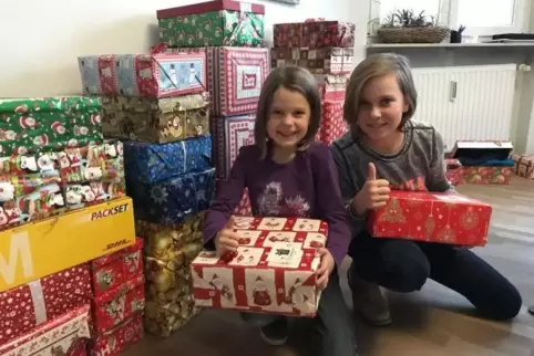 Kinder packen Weihnachtspäckchen für Kinder in Osteuropa.