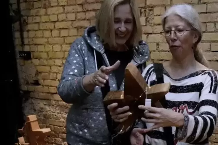 Heike Roehrig (links) zeigt einer Besucherin ihre Holzsterne.
