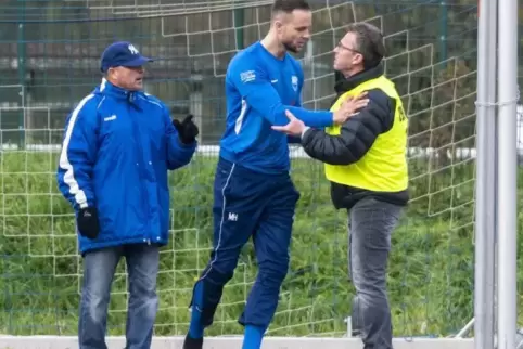 Der ausgewechselte Spieler Daniel Haag (FV Bruchmühlbach) will den Ordner von seinem Trainer Karl-Heinz Halter fernhalten.