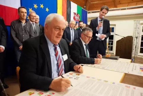 Erst unterzeichnen Jean-Marie Haas (links) und Michael Zwick für die Verbandsgemeinden die Urkunde, dann alle Ortsbürgermeister.