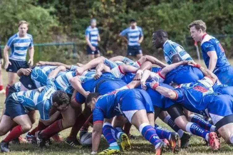 Mitten im Gewühl ist das Rugby-„Ei“: Die SG Hochspeyer (blaue Trikots) trifft auf den RC Luxemburg II (gestreifte Hemden).