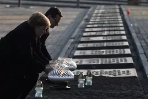 Das Licht des Lebens: Bundeskanzlerin Merkel und der polnische Premier Morawiecki platzieren Kerzen am Denkmal für die Holocaust