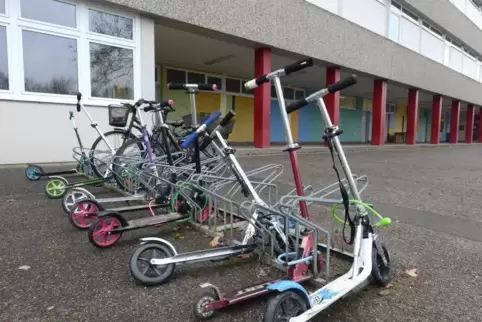 An einer Grundschule abgestellte Tretroller. 