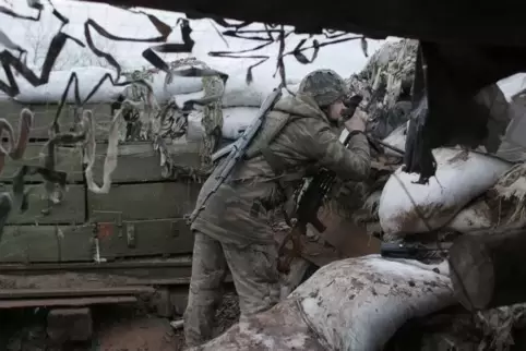 Noch lange kein Frieden: Ein ukrainischer Soldat schaut durch ein Fernglas in vorderster Front in der Stadt Novoluhanske in der 