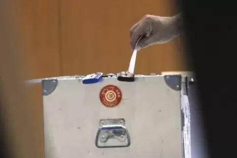 Demokratie: Stimmzettel in die Wahlurne.