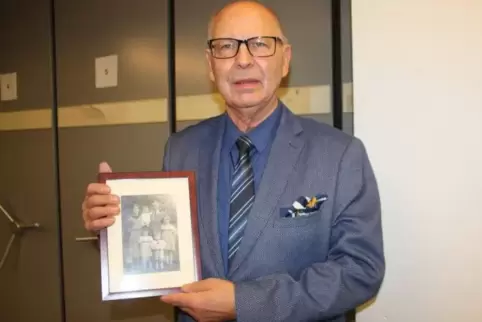 Erinnerung: Volker Schläfer mit einem Foto, das ihn als kleinen Jungen (auf dem Arm des Vaters) mit seinen Eltern und Geschwiste