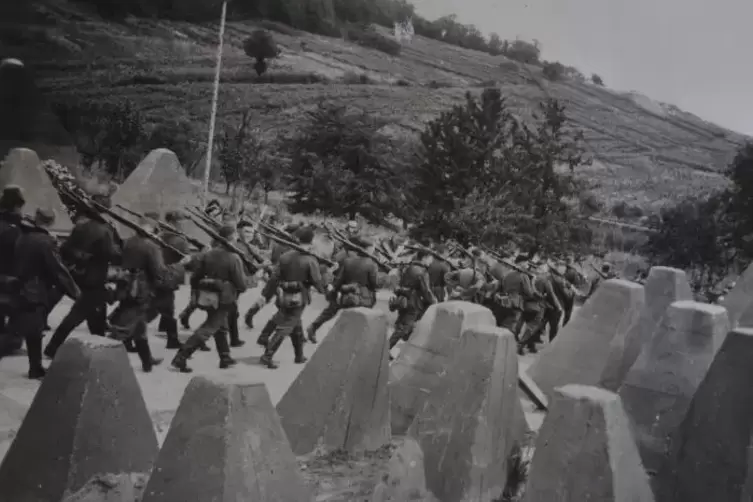 BesinnenDeutsche Soldaten marschieren durch eine sogenannte H&ouml;ckerlinie, die feindliche Panzerangriffe aufhalten soll. Zwischen 