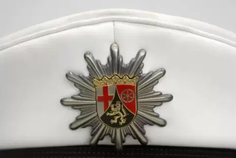Die Mütze eines Polizeibeamten mit dem Logo/Wappen der Polizei in Rheinland-Pfalz. 