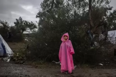 Ein junges Mädchen steht in einem provisorischen Lager neben dem Lager Moria auf der Insel Lesbos im Regen.