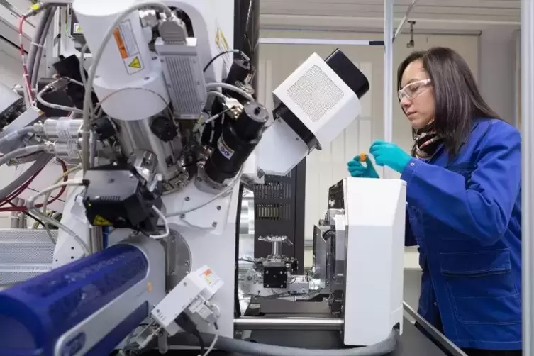 Eine BASF-Mitarbeiterin tauscht eine Probe am Rasterelektronenmikroskop Helios aus. Hier werden hauchd&uuml;nne Lamellen aus der Prob