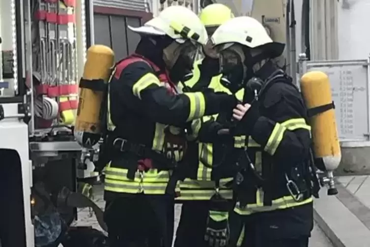 Einsatzkräfte der Feuerwehr werden mit Gasmasken ausgestattet.