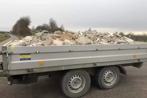 Der Bauschutt ragt deutlich über die Bordwand hinaus.