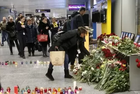 Verwandte und Freunde der Besatzungsmitglieder des ukrainischen Flugzeugs legen Blumen an einer Gedenkstätte im internationalen 