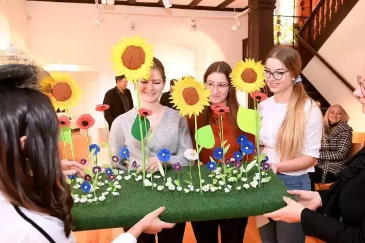 Schülerinnen präsentieren eine ihrer Kreationen für die Ausstellung im Stadtpalais.