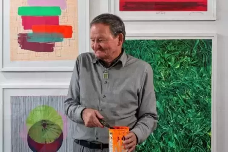 Hans-Peter Haas in seiner Werkstatt vor Drucken von Gerhard Neumaier und Hermann Lederle.