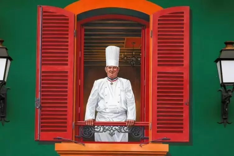 Der verstorbene Sternekoche Paul Bocuse grüßt von einem Gemälde an seinem Restaurant „L’auberge du Pont de Collonges“.