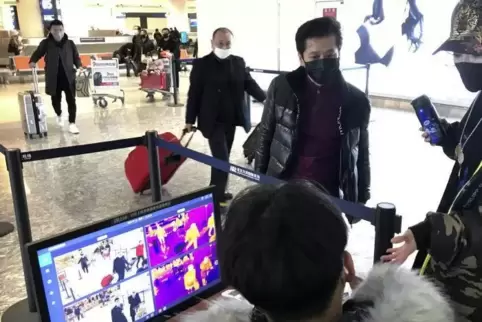 Als Schutzmaßnahme gegen die Verbreitung des Corona-Virus werden Reisende auf dem Flughafen von Wuhan mit Infrarot-Thermometern 