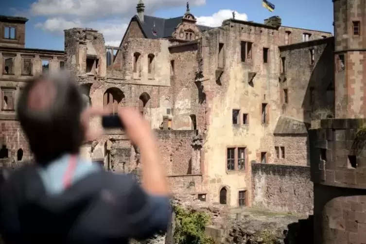 Ein Besucher fotografiert das Heidelberger Schloss.