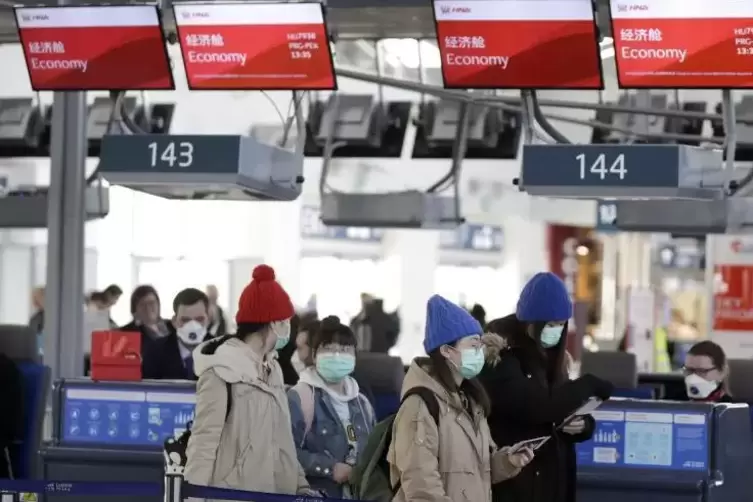 Prag: Passagiere mit Musschutz checken am internationalen Flughafen «Vaclav Havel» für ihren Flug nach Peking ein.